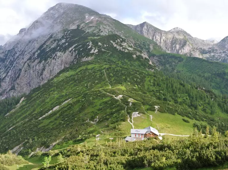 Wanderweg und Hütte in den Berchtesgadener Alpen mit Berglandschaft im Hintergrund.