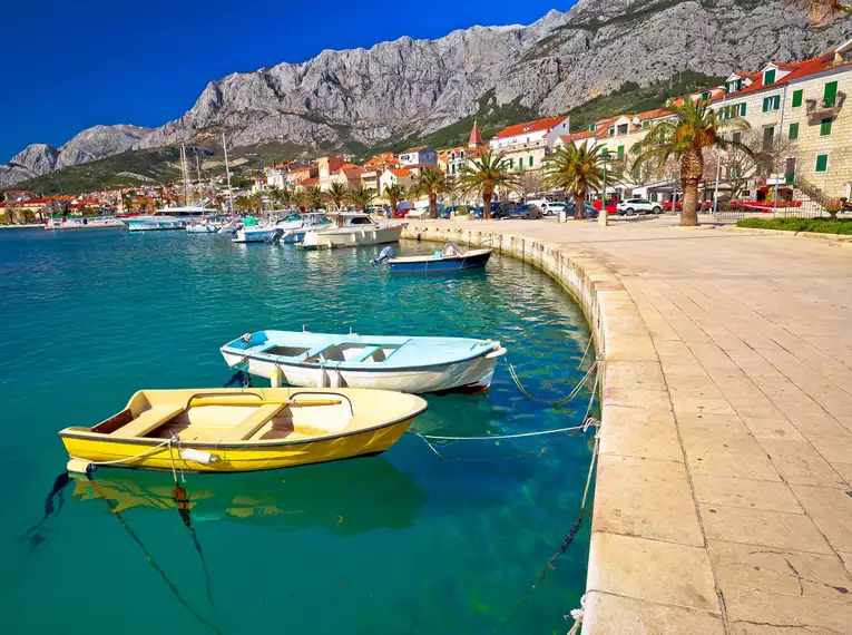 Boote am Kai mit Blick auf das Biokovo-Gebirge bei der Makarska-Riviera.