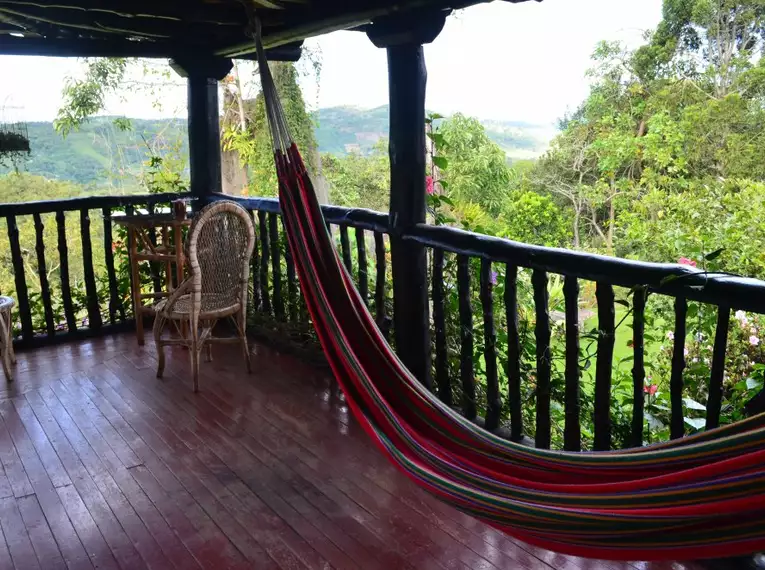 Holzveranda mit Hängematte und Blick ins Grüne in Kolumbien.